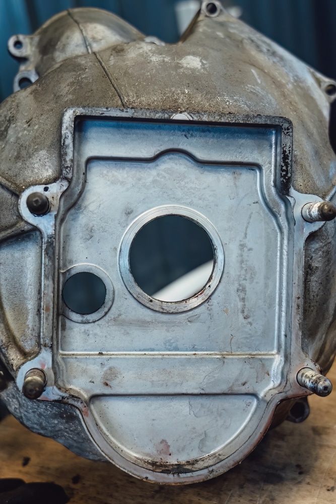 Pièce de Transmission : Boîtier Métallique avec Plaque Boîtier de transmission métallique usagé avec plaque d'adaptation, alésages centraux et goujons de montage.