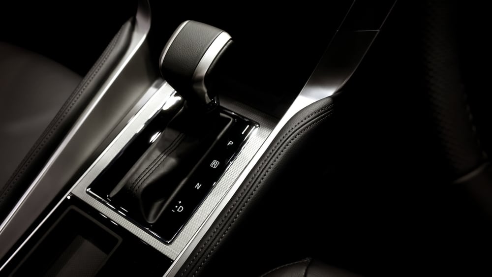 Levier de vitesse automatique moderne : Design et élégance Levier de vitesse automatique moderne en cuir et métal avec marquages P, R, N, D sur une console centrale élégante.